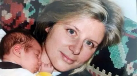 FAMILY HANDOUT A close up of a tiny baby being held by his mother Joanna Simpson
