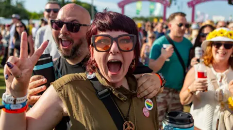 Isle of Wight Festival Festival crowd with couple smiling close-up at the camera.