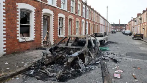 A street with burned out cars 