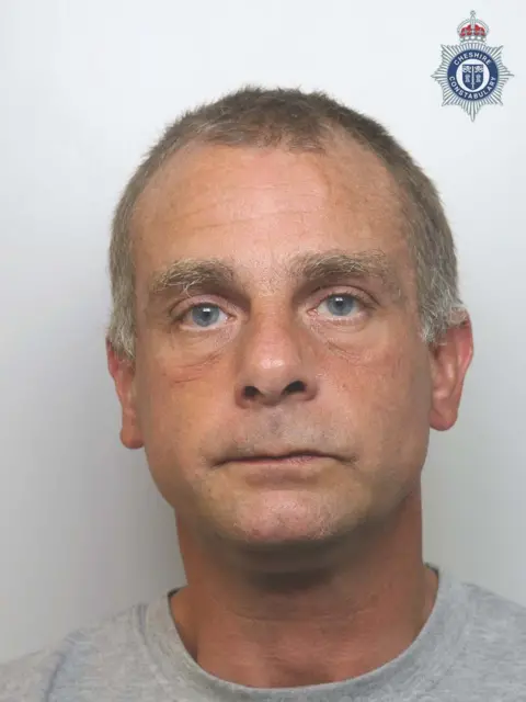 Police custody photograph of Simon Carter looking directly at the camera. He has no expression. 