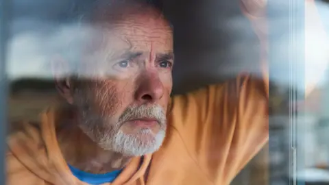 A man of about 70 looks worried