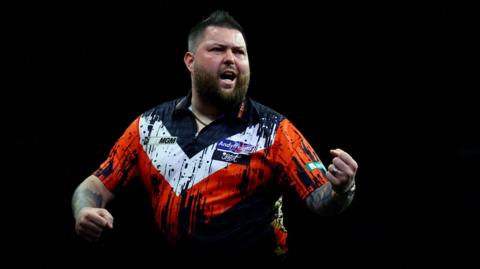Michael Smith celebrates beating Nathan Aspinall to secure his Premier League Darts play-off spot