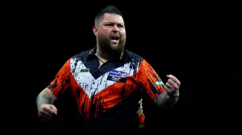 Michael Smith celebrates beating Nathan Aspinall to secure his Premier League Darts play-off spot