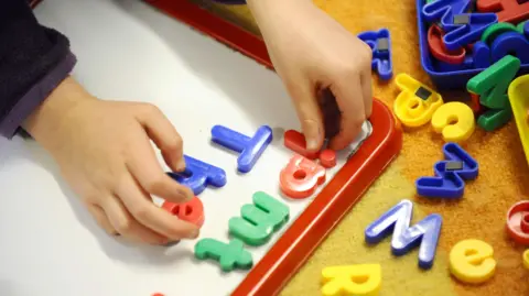A generic image of a child playing with letters on a whiteboard.