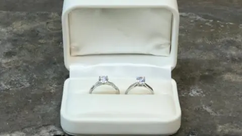 Two diamond rings in a white ring box.