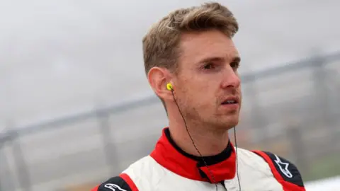 A close up of Paul Rees in a racing suit