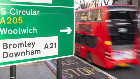 PA Media File image of a bus passing by a sign for the South Circular road in London