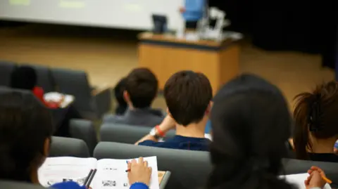 Students reading book in class.