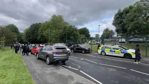 A street scene showing cars outside the school