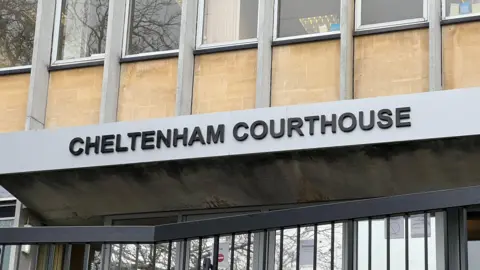 The sign above Cheltenham Magistrates' Court door, which reads "Cheltenham Courthouse" in black lettering