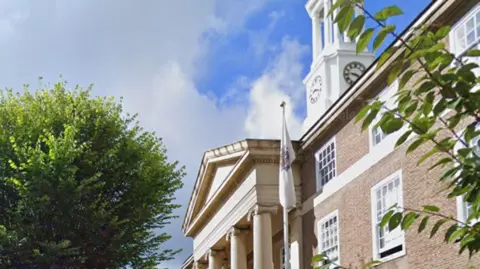 Google Outside the headquarters of Worthing Borough Council. A large brick building with large stone pillars at its entrance.