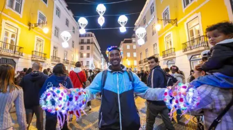 Getty image street vendor smiles on a beautiful lisbon street at night