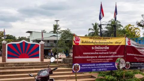 A sign against scam centre displayed at the border
