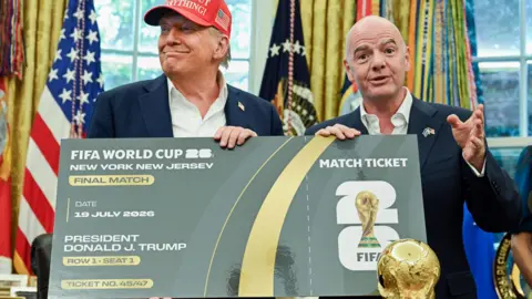 US President Donald Trump and Uefa president Gianni Infantino pose with a giant mock World Cup ticket