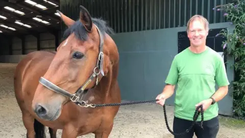 Steve Jones Steve Jones, who is wearing a agleam greenish shirt, pictured pinch a brownish horse.