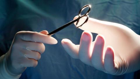 Surgeon's hands and a pair of scissors
