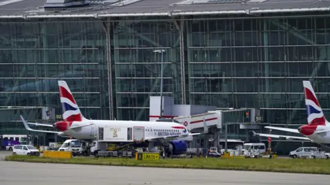 PA Heathrow Airport Terminal 5 showing a British Airways plane parked outside the terminal building