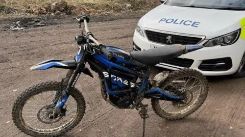 Illegal off-road bike in front of police car