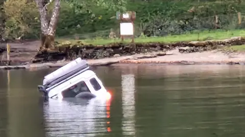 Anca Powell The Land Rover seen from the back before a tractor helped pull it out of Windermere.