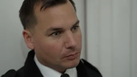 Ch Supt Matthew Peach looks off camera