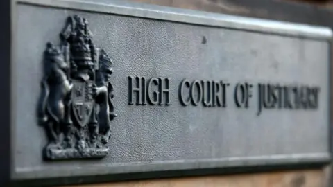 PA Media Grey sign saying 'High Court of Justiciary' outside the High Court in Edinburgh.