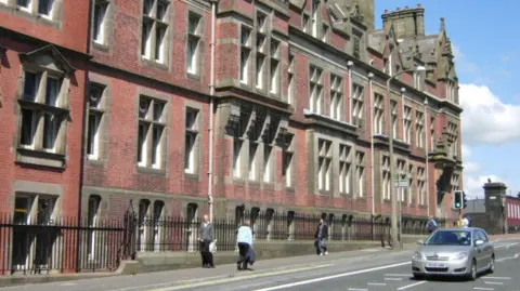 Stephen McKay/Geograph A scene shot of the red brick Preston County Hall, with pedestrians and a car moving past