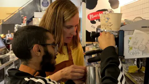 Muriel and Ibraheem at a coffee machine