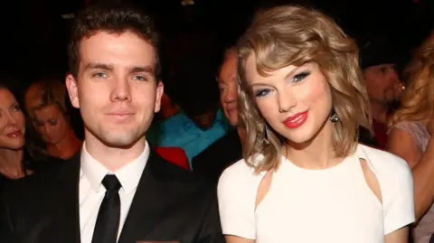 Getty Images Austin and Taylor Swift sitting together and smiling at the Annual Academy of Country Music Awards in 2014 in Las Vegas