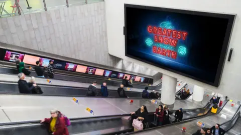 Global Escalators at a Tube station lined with digital advertising screens