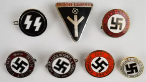 Harper Field A screenshot taken from the Harper Field auctioneers website showing seven badges embellished with the Swastika.