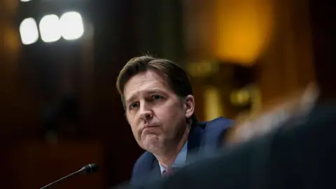 Ben Sasse sits in front of microphone