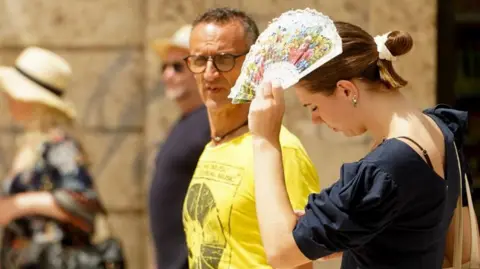 Getty Woman with fan Valencia 2023