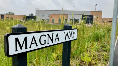 David Freezer/BBC A road sign displaying the name "Magna Way" in the foreground with a medical centre in the background.