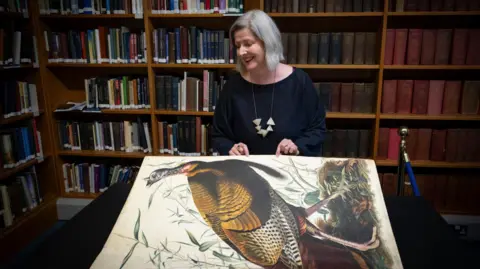 Kirsty Anderson/Royal College of Physicians and Surgeons of Glasgow  Claire McDade turning the page of the book