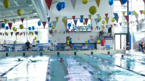 BBC Swimming pool with multiple lanes and balloons and bunting for the swimarathon.