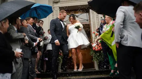 Yui Mok / PA Media Newly married couple Jack and Katie Webster walk down the steps at Old Marylebone Town Hall