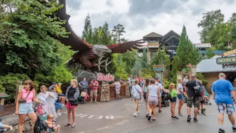 Getty Images A large statue of an eagle with spread wings is in the midst of a theme park swarming with visitors
