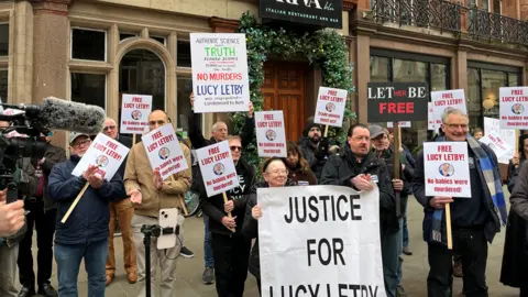 Protesters outside the public inqury hold up 'Justice for Lucy Letby' signs