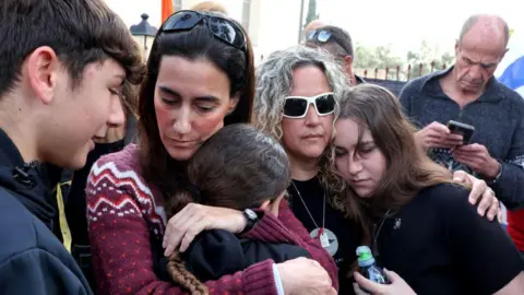 AFP Batsheva Yahaalomi (2nd L), French -Israeli hostile wife, Ohdh Yahlumi, Yahlomei's sister (C) sad outside a morgue where his body has been delivered since she was handed over Hamas, in Rishon Leson, Central Israel (5 March 2025)