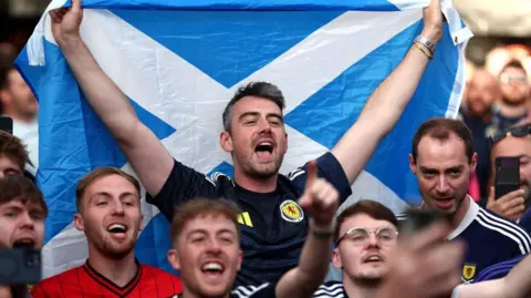 Getty Images A Scotland fan holding a Saltire cheers 