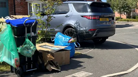 A stack of recycling containers outside a home