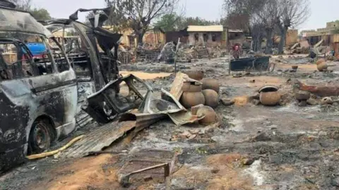 Getty Images Gambar yang diambil pada 1 September 2023 ini menunjukkan pemandangan kehancuran – termasuk mobil yang terbakar – di kawasan pasar ternak di al-Fasher, ibu kota negara bagian Darfur Utara, Sudan. 