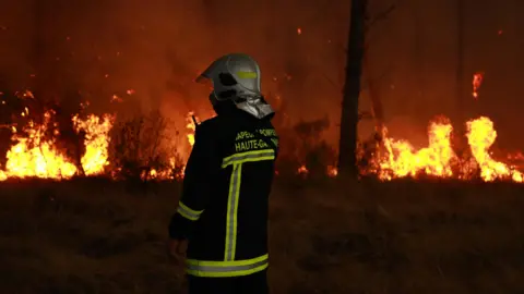 Anadolu via Getty Images French firefighter battles fire