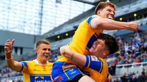 Leeds Rhinos winger Riley Lumb celebrates his opening try against St Helens by lifting up Morgan Gannon