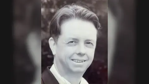 Family Photograph A black and white photograph of Simon Scott wearing a dark suit and a white shirt