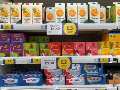Christopher Furlong/Getty Images Shelves of juice at Tesco with a big sign advertising Clubcard prices