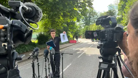 A police officer holding up an image of a man