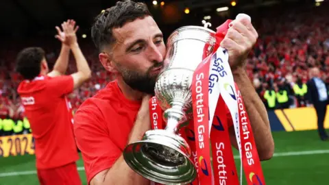 Aberdeen Captain Graeme Shinnie celebrates with the Scottish Gas Scottish Cup Trophy during the Scottish Gas Men's Scottish Cup Final between Aberdeen and Celtic at Hampden Park, on May 24, 2025, in Glasgow, Scotland. 