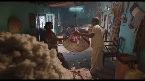 For the door of courtesy: Sthal A from Sthal: The match of an elderly couple weighing cotton appears on a suspended scale of the ceiling inside the room. There is a huge pile of newly captured cotton