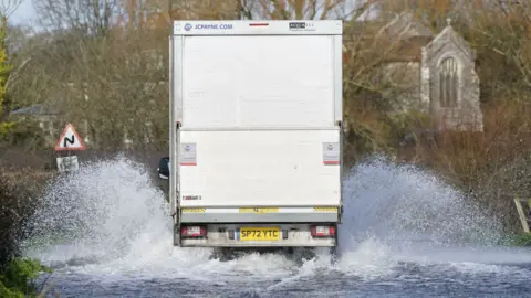 Van driving through flooded road
